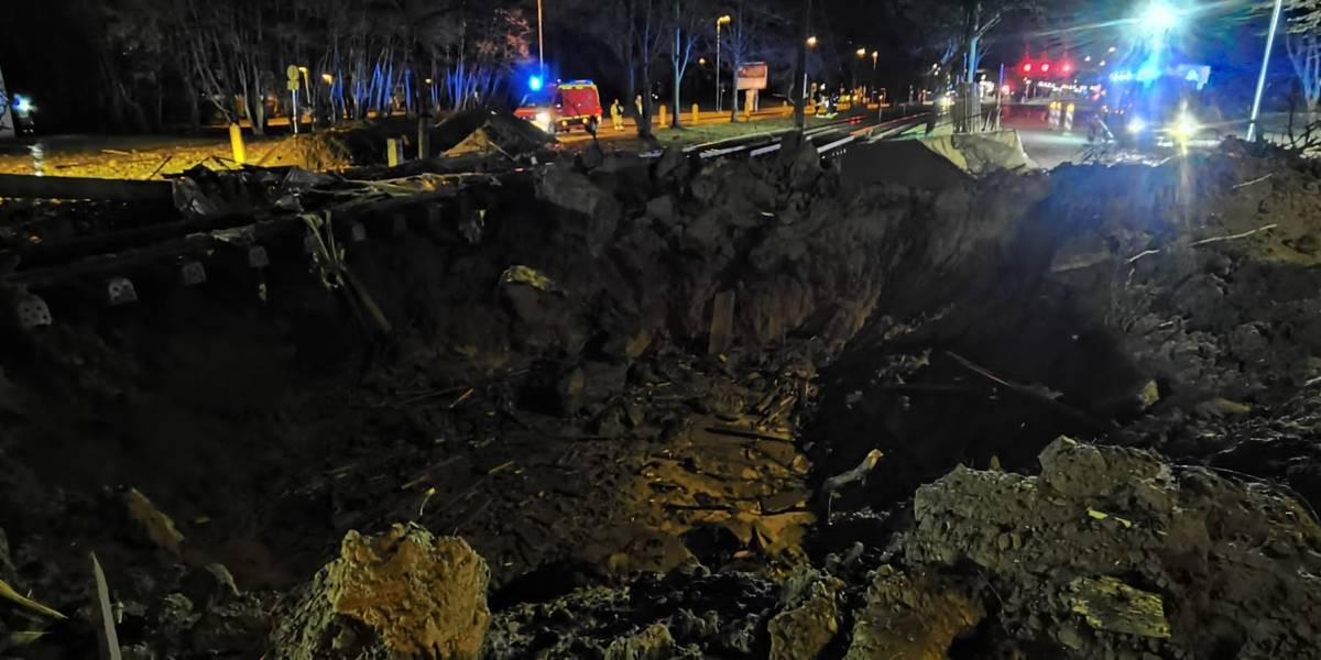 Ein großes Loch mit Straßenschäden an einer Straße.