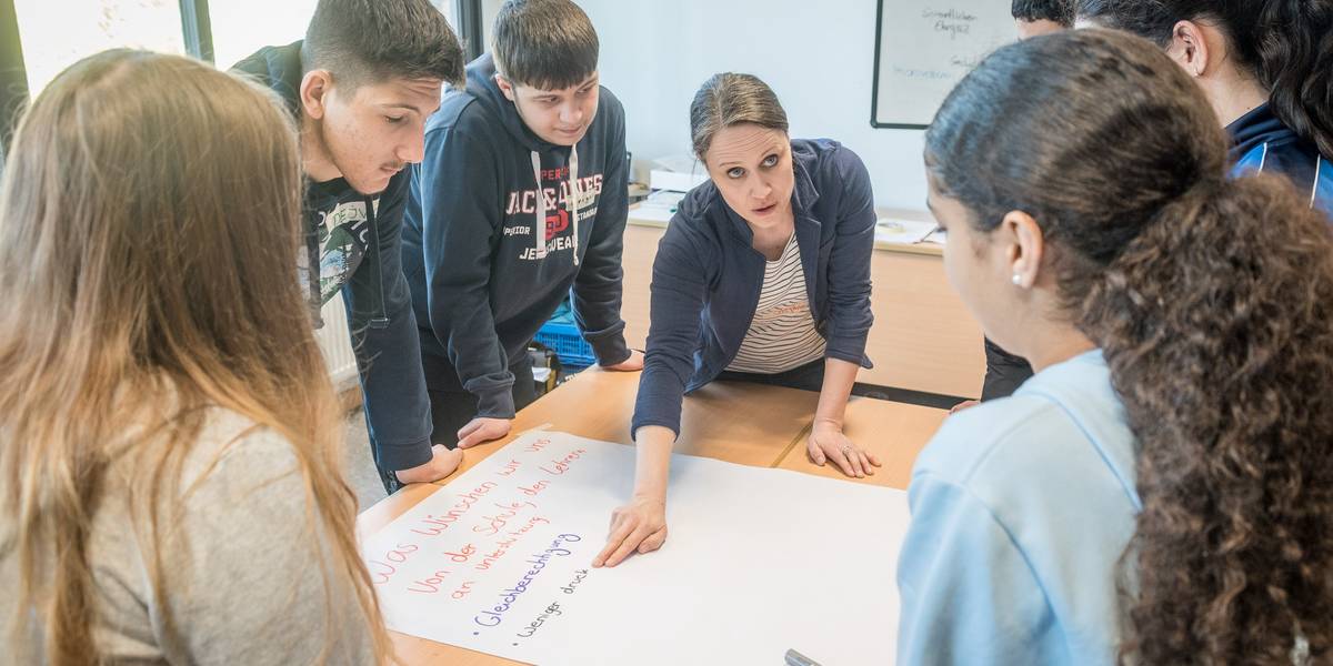Schülerinnen und Schüler in einer Gruppe an einem Tisch.