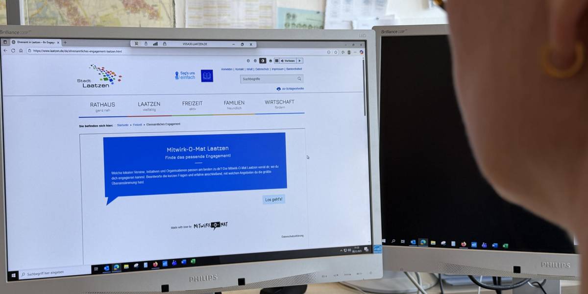 Eine Frau sitzt vor einem Bildschirm.