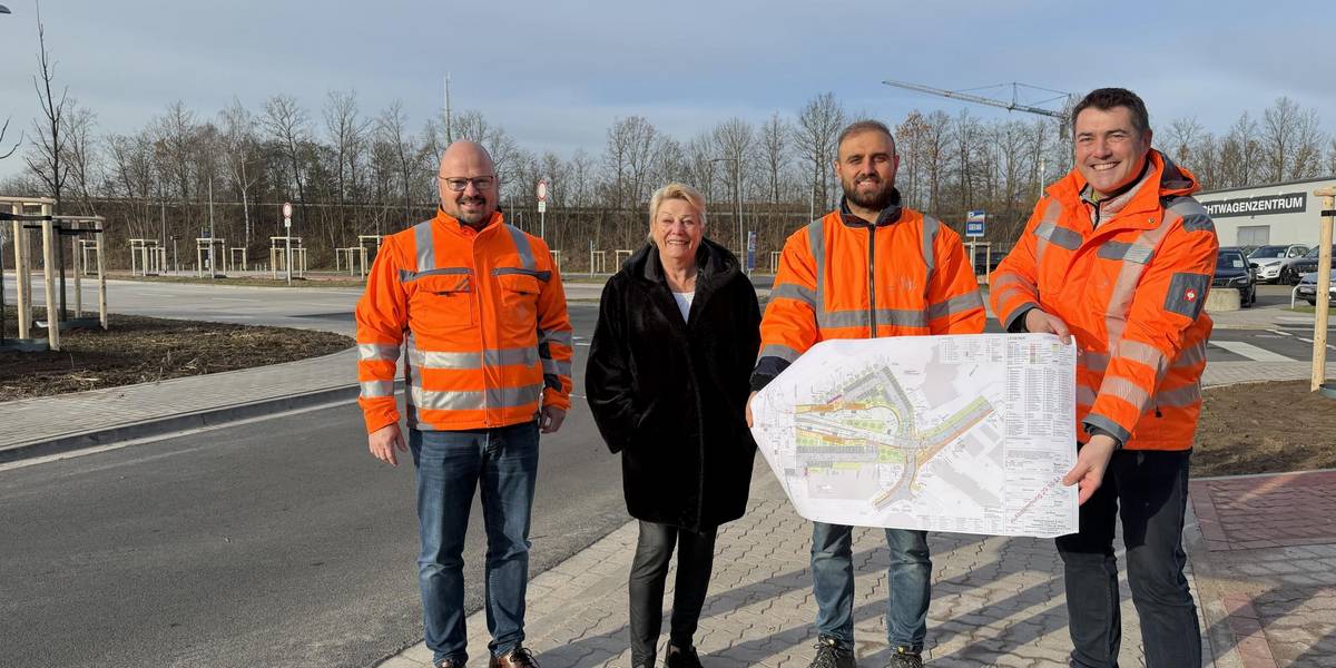 Freuen sich über die Fertigstellung: Laatzens Bürgermeister Kai Eggert, Rethens stellv. Ortsbürgermeisterin Hannelore Flebbe mit Burhan Al Khalaf und Olaf Klaus-Pohl vom Team Tiefbau der Stadt Laatzen. © Stadt Laatzen Drei Männer in orangenen Warnjacken und eine Frau stehen an der Einmündung einer neuen Straße auf dem Gehweg.