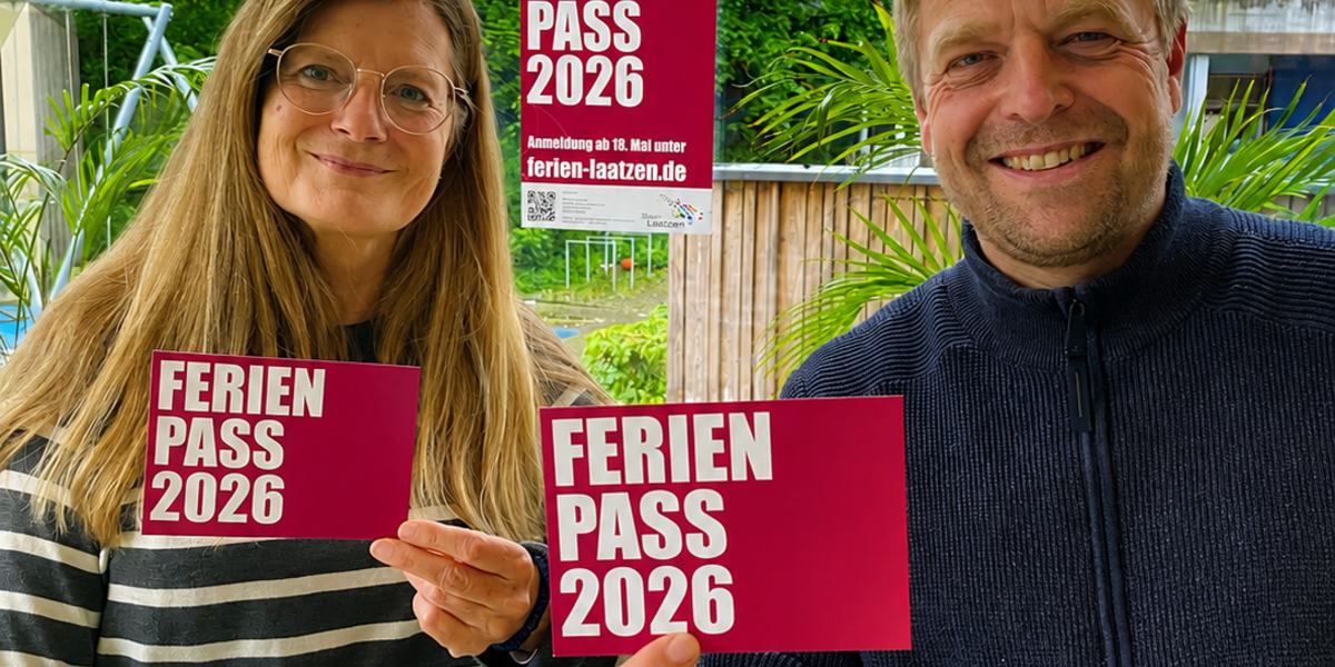 Eine Mitarbeiterin und ein Mitarbeiter des Kinder- und Jugendbüros halten Flyer mit dem Programm des Ferienpasses in die Kamera.