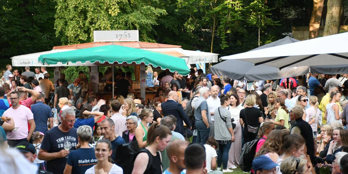 Winzerfest 2025 © Stadt Laatzen Viele Personen, die auf einer Wieser unter Sonnenschirmen sitzen.