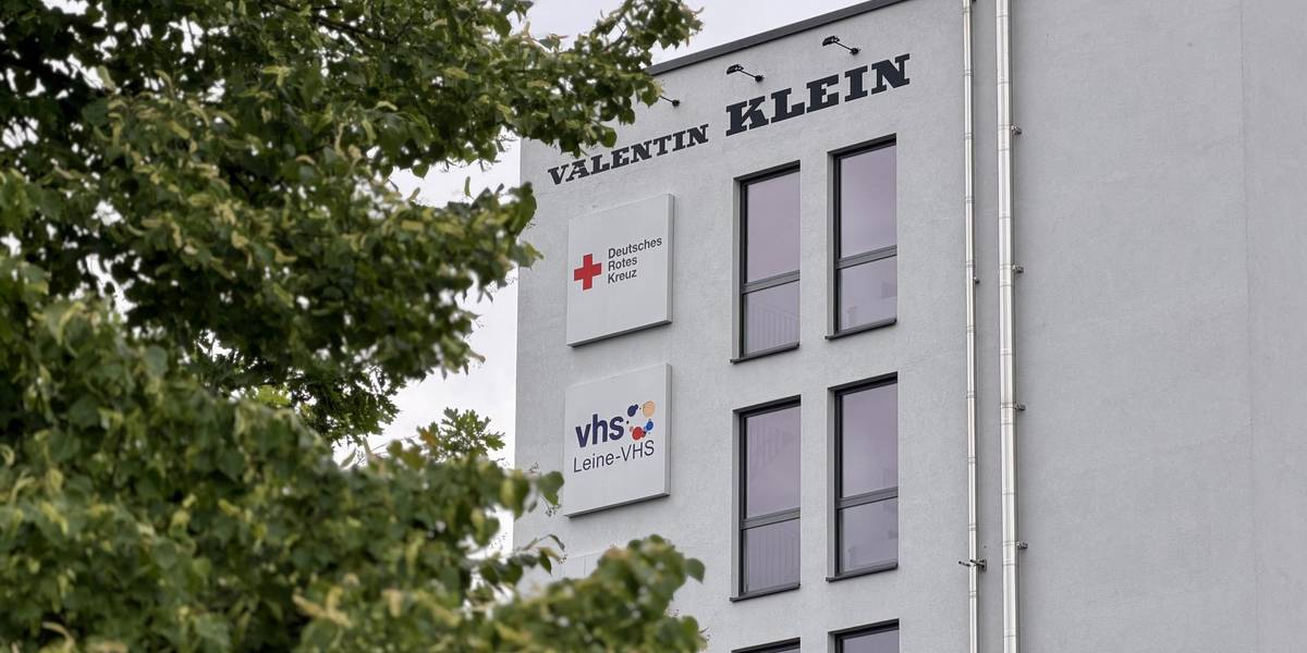 Außenaufnahme eines weiß verputzten Gebäudes mit einem Schild der Leine-VHS