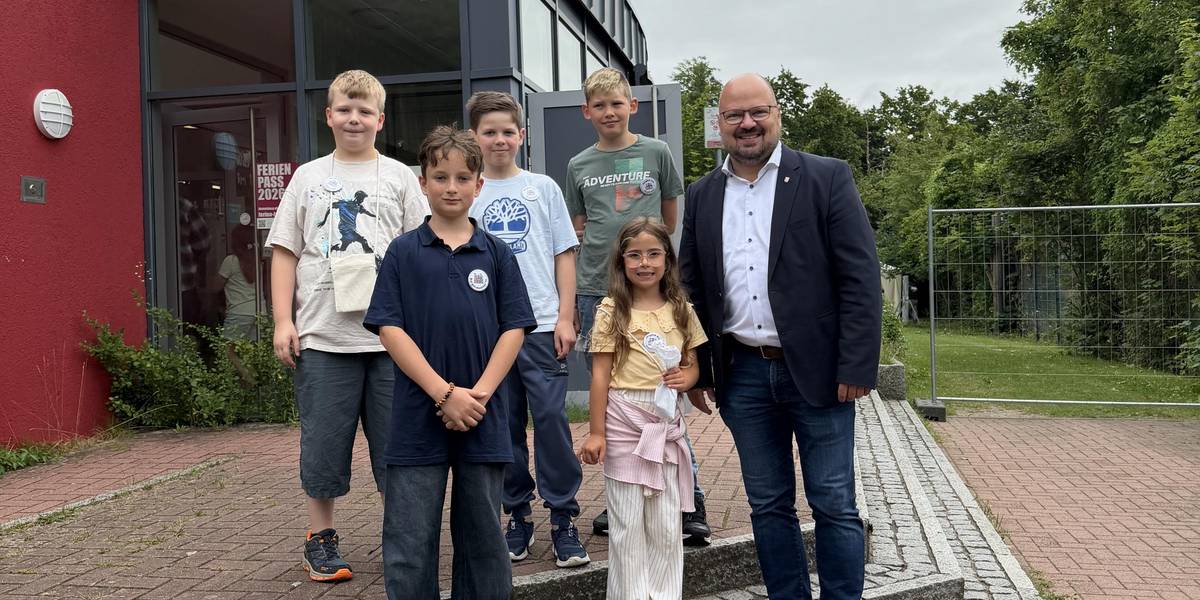 Kinderrat mit Bürgermeister Kai Eggert © Stadt Laatzen Kinder und ein Mann stehen vor einem Gebäude auf Stufen.