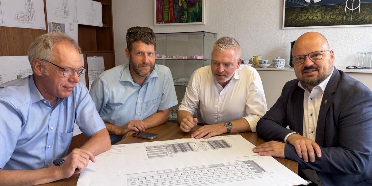 Vorstellung der Pläne zum Projekt E.A.S.y: Uwe Fleischmann, Team Bauordnung, Hauke Schröder, Stadtrat, Investor Michael Eric Schrader, TeGa Immobilien GmbH und Bürgermeister Kai Eggert. (von links) © Stadt Laatzen Eine Gruppe von vier Männern sitzt an einem Tisch. Auf dem Tisch liegt ein Plan.