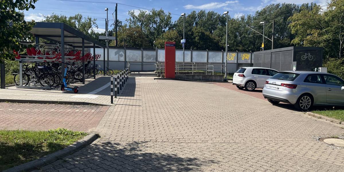 Bike & Ride Station in Rethen © Stadt Laatzen Parkplatz mit zwei Autos und der Park Und Ride Station mit Fahrrädern.