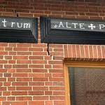 Eine rote Backsteinmauer ist mit Rissen durchzogen.