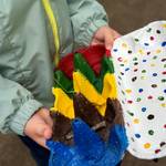 Farbensafari © Stadt Laatzen Eine Kinderhand hält einen in rot, grün, gelb und braun bemalten Eierkarton