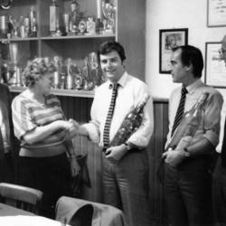 Gruppenfoto mit 5 Personen, im Hintergrund zahlreiche Pokale.