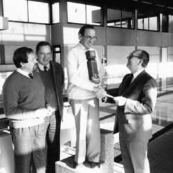 Stadtdirektor Panitz (ganz rechts) ehrt einen Herrn in einem Hallenbad, daneben zweite weitere Herren.