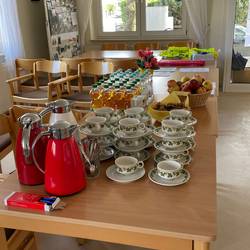 Tassen, Kaffekannen und Lebensmittel auf einem Tisch.