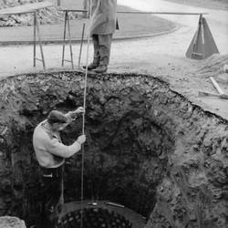 Zwei Bauarbeiter, im Hintergrund Straße und Bäume