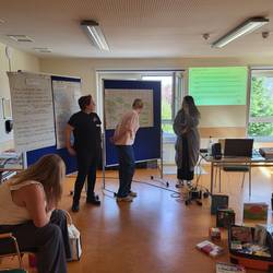 3 Fachkräfte präsentieren ihre Ergebnisse an einer Flipchart.