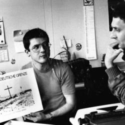 Zwei Männer mit einem Bild "Deutsch-Deutsche Grenze"