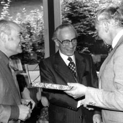 Geschenkübergabe mit drei Herren