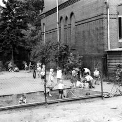 Schüler auf Spielplatz vor Schulgebäude