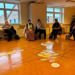 Große Arbeitsgruppe © Karen Schlote/ Stadt Laatzen Die Teilnehmer sitzen im Kreis. In der Mitte liegen Metaplankarten, die einem bestimmten Bereich zugeordnet sind.