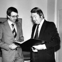 Landrat Jürgen Bauermeister ehrt einen Herrn mit Anzug und Brille.