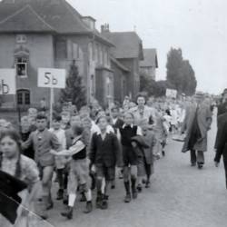 Schüler mit Schild der Klasse marschieren durch die Straßen