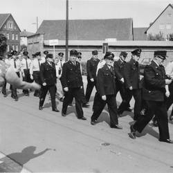 Männer in Uniformen marschieren Straße entlang