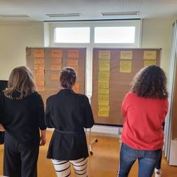 Die Fachkräfte eignen  sich Inhalte an.  Die Inhalte stehen an einer  Pinnwand. Beispiel: Nachfragen- Bitten sie die Kinder, genauer zu beschreiben, was sie meinen.