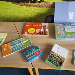 Auf einem Tisch liegen unterschiedliche Bücher zum Thema Reflexion.