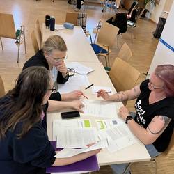 Arbeitsgruppe © Stadt Laatzen/ Karen Schlote Drei Teilnehmende sitzen an einem Tisch und arbeiten einen Fachtext mit einer Fragestellung durch.