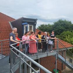 Die Teilnehmenden gucken sich das Außengelände vom Balkon an.