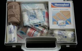 Ein geöffneter Erste-Hilfe-Koffer mit Pflastern und Verbänden