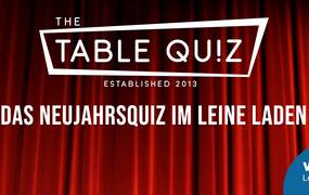 Roter Vorhang, davor weißes Table Quiz Logo, unten rechts Logo Leine-VHS vor blauem Kreis, Text: Das Neujahrsquiz im Leine Laden