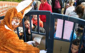 Mann im Hasenkostüm öffent das Tor zum Park der Sinne