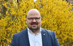 Portraitfoto von Bürgermeister Kai Eggert vor blühenden Forsythien