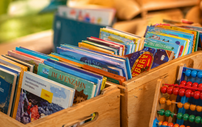 verschiedene Bücherkisten, ein Abakus lehnt davor