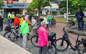 Eine Gruppe Radfahrer versammelt sich vor dem Rathaus.