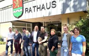 Eine Gruppe Männer und Frauen stehen vor dem Rathaus der Stadt Laatzen