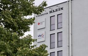 Außenaufnahme eines weiß verputzten Gebäudes mit einem Schild der Leine-VHS
