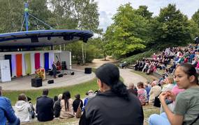 Volle Ränge vor einer Freiluftbühne im Sommer