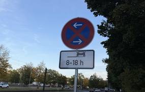 Schild steht an einer Straße.