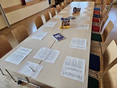 Tischreihen mit Zetteln.