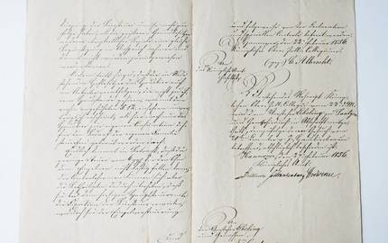 Aufgeschlagenes Buch, eine historosche Handschrift auf vergilbtem Papier ist zu sehen.