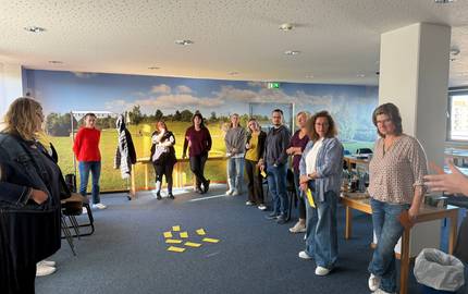 Die Fachkräfte erarbeiten sich ein Thema © Britta Hanke Die Fachkräfte stehen im Halbkreis und legen in die Mitte Metaplankarten. Sie erharbeiten sich ein Thema.