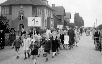 Schüler mit Schild der Klasse marschieren durch die Straßen