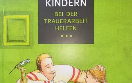Ein Foto von einem Kinderbuch wird gezeigt. Das Kinderbuch hat den Titel "Kindern - bei der Trauerarbeit helfen".