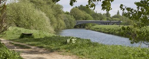Wanderweg an der Leine, im Hintergrund eine Leinebrücke