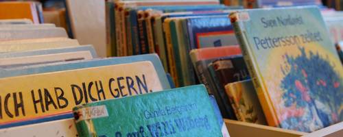 verschiedene Kinderbücher stehen in einer Bücherkiste