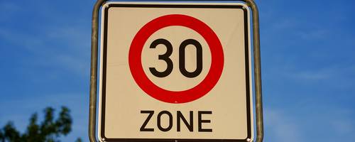 Schild vor blauem Himmel mit einer roten 30