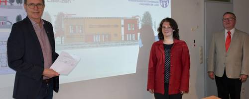 Drei Personen vor einer Bauzeichnung