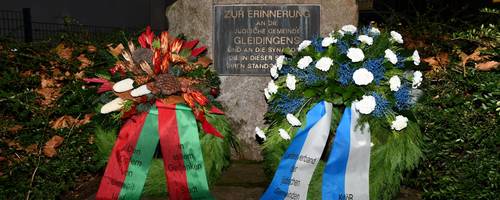 Ein Gedenkstein mit zwei feierlichen Kränzen.