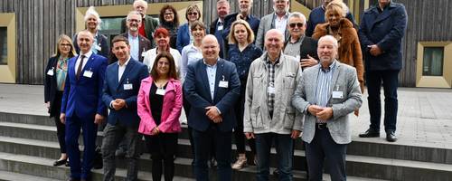Eine Gruppe mit Abgeordneten aus unterschiedlichen Ländern stehen vor dem Stadthaus in Laatzen.