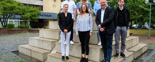 Eine Gruppe von Frauen und Männern auf dem Brunnen vor dem Rathaus.